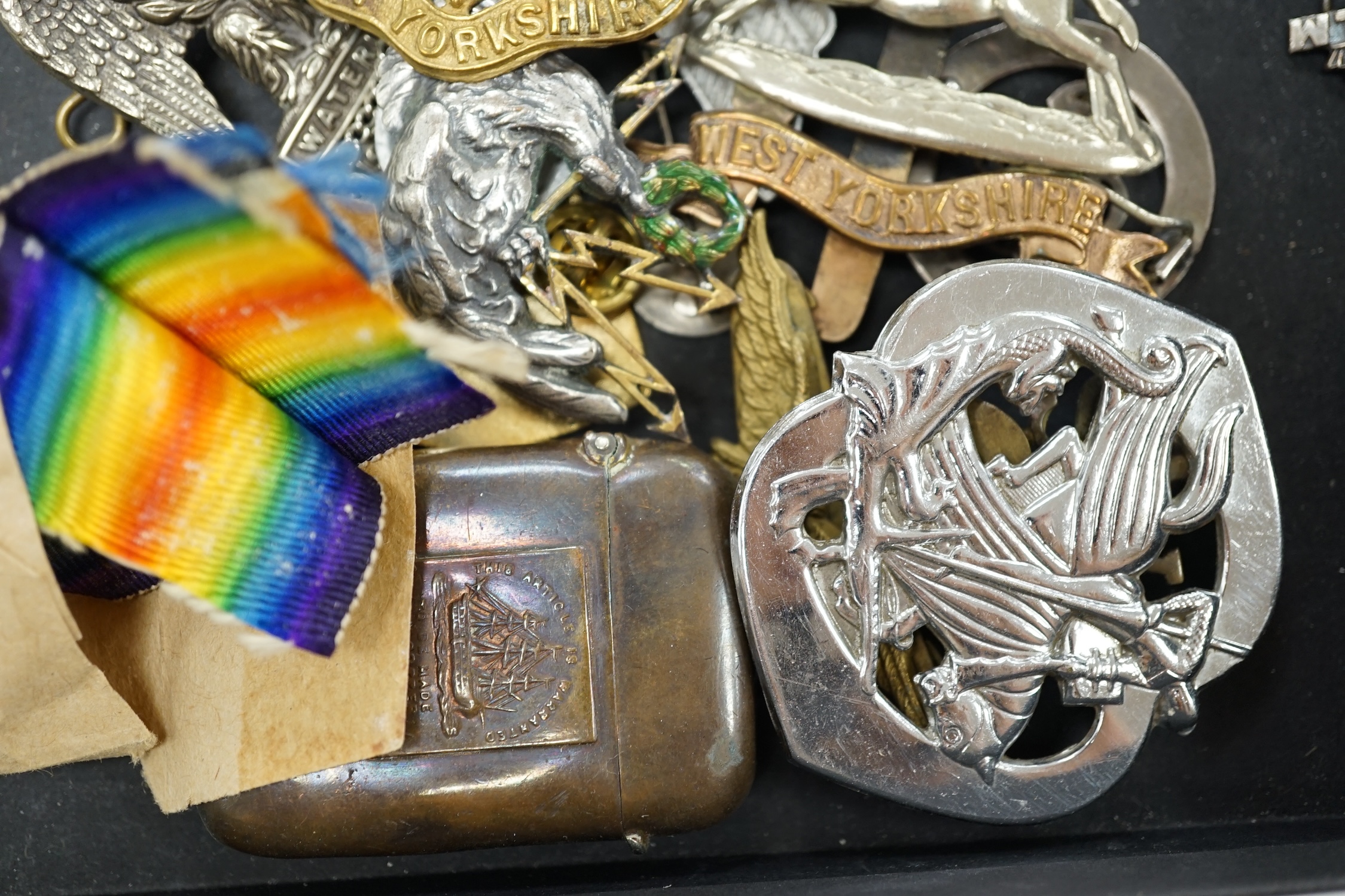 A collection of military cap badges and medals, including a First World War medal pair awarded to A.M. F.W. Wright, together with seventeen British and German cap badges including; the West Yorkshire Regiment, the Royal